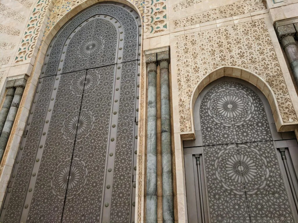 Morocco’s Imperial Cities: A Journey Through History, Culture and Local Life Close-up of intricate Moroccan geometric patterns on a mosque door.