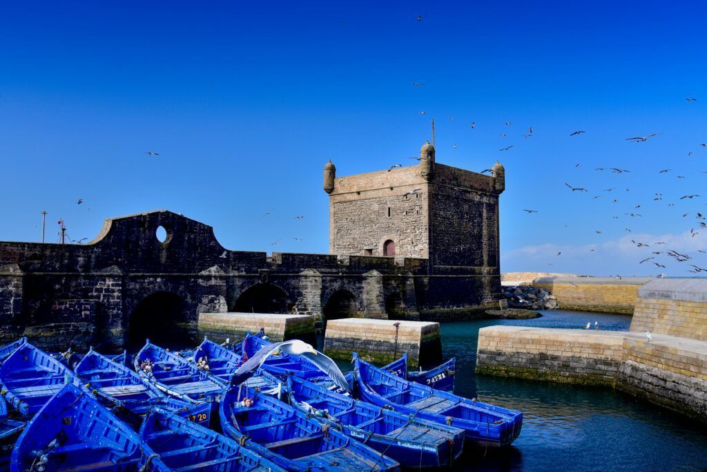 Tranquil scene of boats and fortress in Essaouira, Morocco.